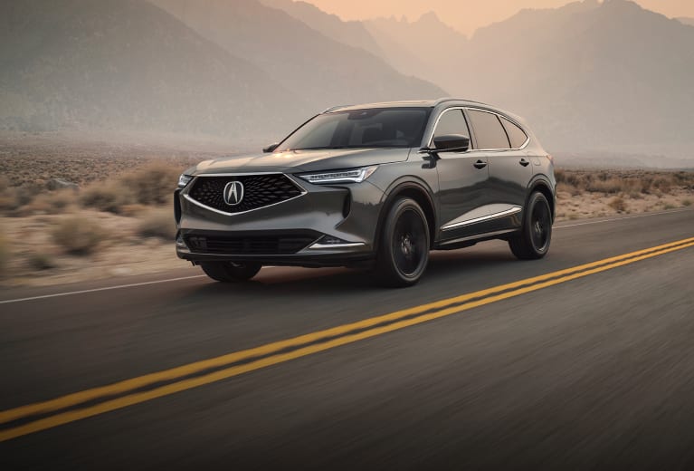 An Acura MDX in Liquid Carbon Metallic driving on a desert highway